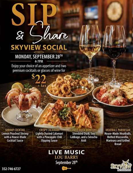 A spread of appetizers including shrimp cocktail, calamari, wontons, and meatball parmesan with wine glasses at the Skyview restaurant.
