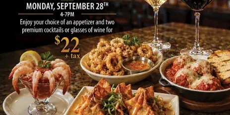 A spread of appetizers including shrimp cocktail, calamari, wontons, and meatball parmesan with wine glasses at the Skyview restaurant.