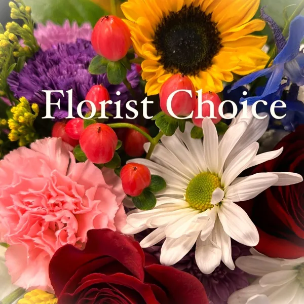 A colorful floral arrangement featuring a sunflower, red roses, pink carnations, and white daisies.