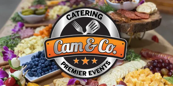 A catering spread featuring a charcuterie board, fresh fruit, and appetizers with a Cam & Co. Catering logo overlay.