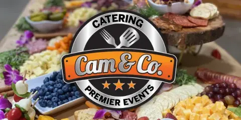 A catering spread featuring a charcuterie board, fresh fruit, and appetizers with a Cam & Co. Catering logo overlay.