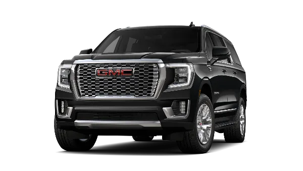 A black GMC Yukon SUV photographed against a black background.