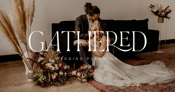 A wedding couple sitting on a black sofa surrounded by floral arrangements with the text 'GATHERED WEDDING PLANNING' overlaid.