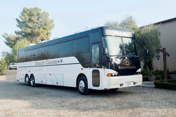 A white and black Royalty Coaches charter bus parked outdoors.