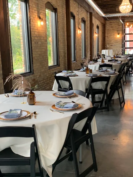 Interior view of The Mill Site event venue with set tables and brick walls.
