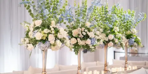 Four large floral arrangements with white roses and ornate greenery