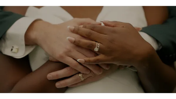 Close-up of a couple's hands holding each other, showing wedding rings.