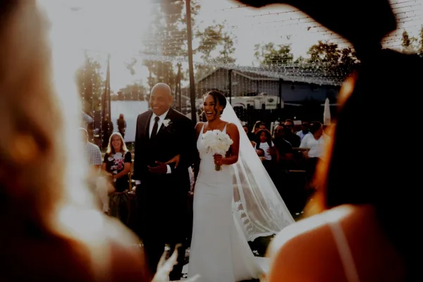 A bride and groom walking down the aisle during an outdoor wedding ceremony.