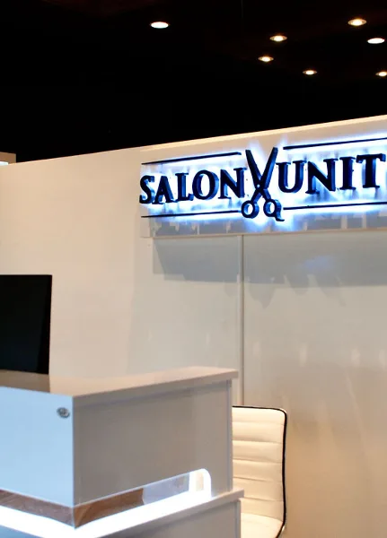 Interior view of Salon Unity showing the reception desk and illuminated business sign.