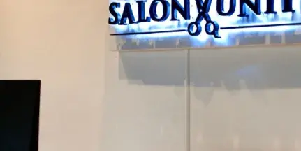 Interior view of Salon Unity showing the reception desk and illuminated business sign.