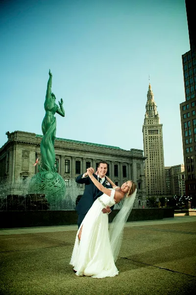 A bride and groom dancing in front of the Cleveland City Hall and Terminal Tower.