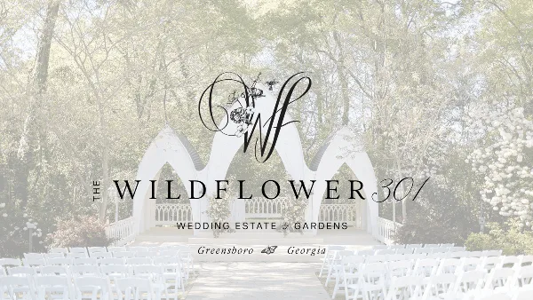Outdoor wedding ceremony setup with white arch and rows of chairs in a garden setting.