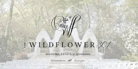 Outdoor wedding ceremony setup with white arch and rows of chairs in a garden setting.