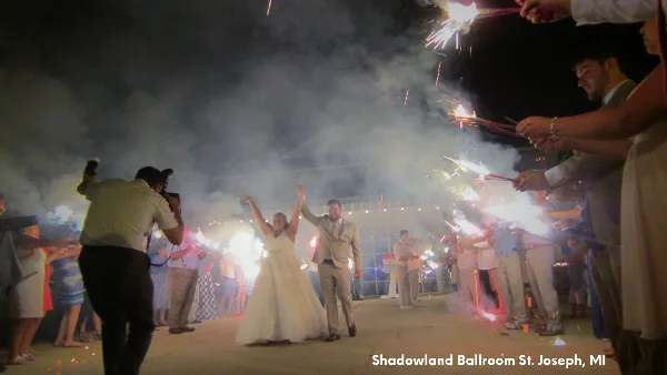 A bride and groom walking through a sparkler tunnel at a wedding reception at Shadowland Ballroom in St. Joseph, MI.