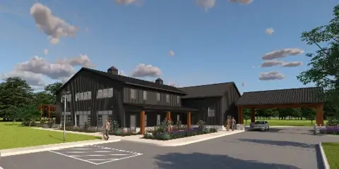 Exterior view of the Ember Wood Events venue building with a parking lot and green lawn.