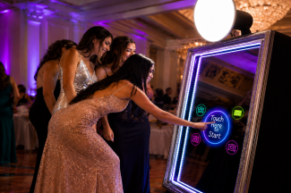 Guests interacting with a Mirror Me Photo Booth at a wedding event