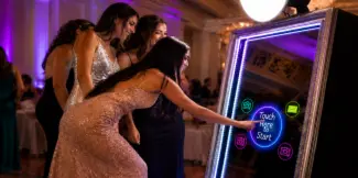 Guests interacting with a Mirror Me Photo Booth at a wedding event