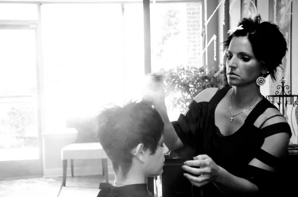 A hair stylist styling a client's hair in a salon.