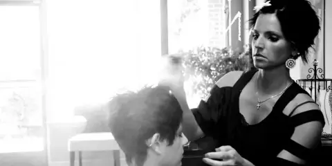 A hair stylist styling a client's hair in a salon.