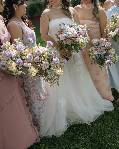 Bride and bridesmaids holding colorful floral bouquets