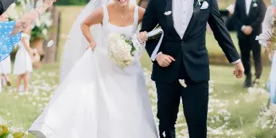 A bride and groom walking down a petal-strewn aisle during a wedding ceremony.