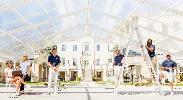 Gulf Coast Events & Rentals staff installing a clear event tent in front of a venue building