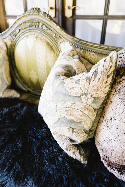 Vintage ornate sofa with decorative pillows and fur throw