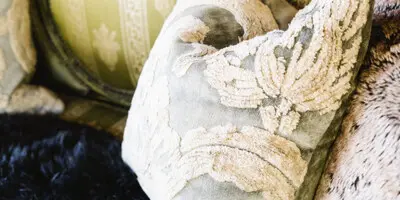 Vintage ornate sofa with decorative pillows and fur throw