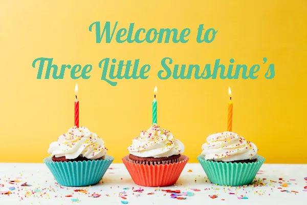 Three cupcakes with white frosting and lit candles on a yellow background with the text 'Welcome to Three Little Sunshine's'.