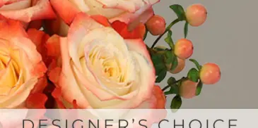 A floral arrangement featuring peach and white roses with green foliage and berries.