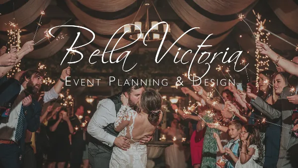 A wedding couple kissing during a sparkler exit at a reception, with the text 'Bella Victoria Event Planning & Design' overlaid.