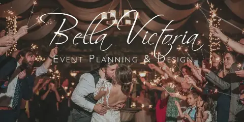 A wedding couple kissing during a sparkler exit at a reception, with the text 'Bella Victoria Event Planning & Design' overlaid.