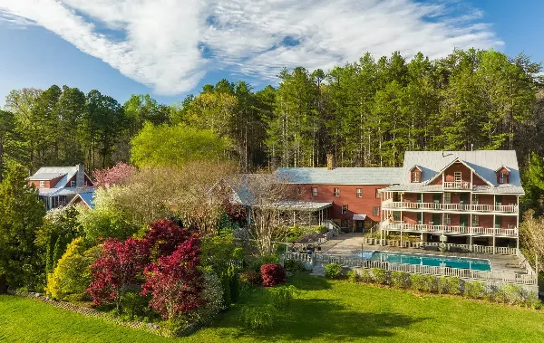 Aerial view of the Glen-Ella Springs Inn historic bed and breakfast building with a swimming pool and lush greenery.