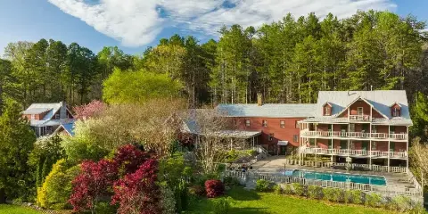 Aerial view of the Glen-Ella Springs Inn historic bed and breakfast building with a swimming pool and lush greenery.