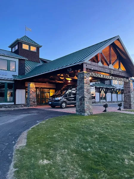 A black passenger van parked at the entrance of Atkinson Resort & Country Club.