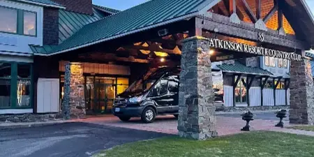 A black passenger van parked at the entrance of Atkinson Resort & Country Club.