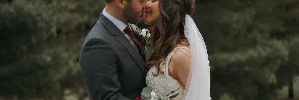 A cinematic close-up of a bride and groom sharing an intimate moment outdoors.