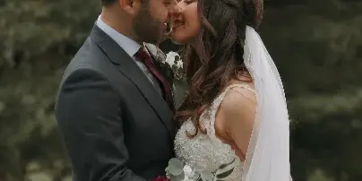 A cinematic close-up of a bride and groom sharing an intimate moment outdoors.