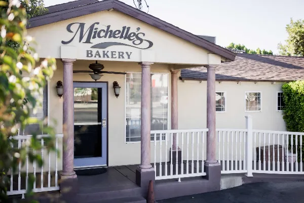 Exterior view of Michelle's Bakery storefront with columns and white railing
