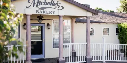Exterior view of Michelle's Bakery storefront with columns and white railing