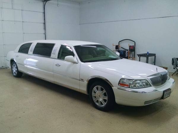 A white stretch limousine parked inside a garage.
