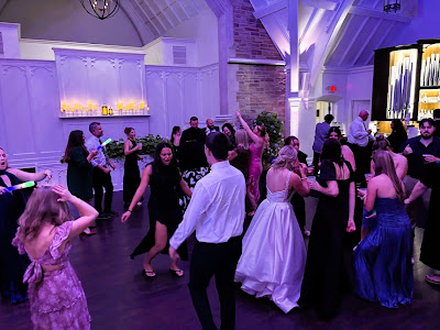 Guests dancing at a wedding reception in a ballroom.