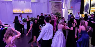 Guests dancing at a wedding reception in a ballroom.