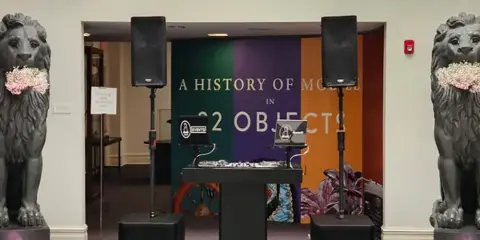 Professional DJ booth with turntables, mixer, and speakers set up at an event venue.