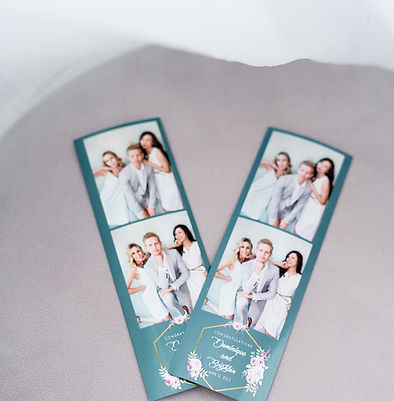 A printed photo booth strip showing a wedding couple with a customized digital overlay.