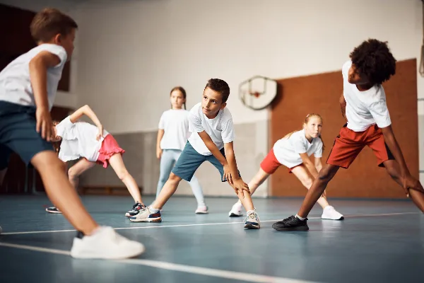 Children playing basketball in an indoor gymnasium