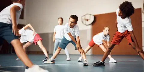 Children playing basketball in an indoor gymnasium