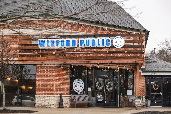 Exterior view of the Wexford Public restaurant building featuring a brick facade and prominent blue signage.