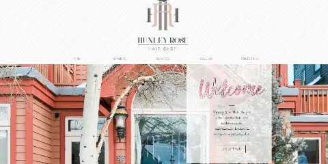 Exterior view of a red wooden building with a storefront window, identified as Huxley Rose Hair Shop in Breckenridge, Colorado.