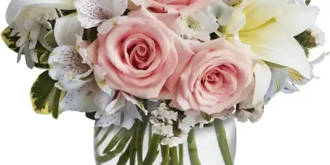 A floral arrangement featuring pink roses, white lilies, and alstroemeria in a clear glass vase.